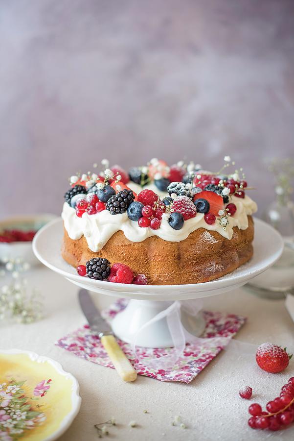 Vanilla Bundt Cake With Cream Cheese Icing And Berries On A Cake Stand Photograph by Magdalena Hendey