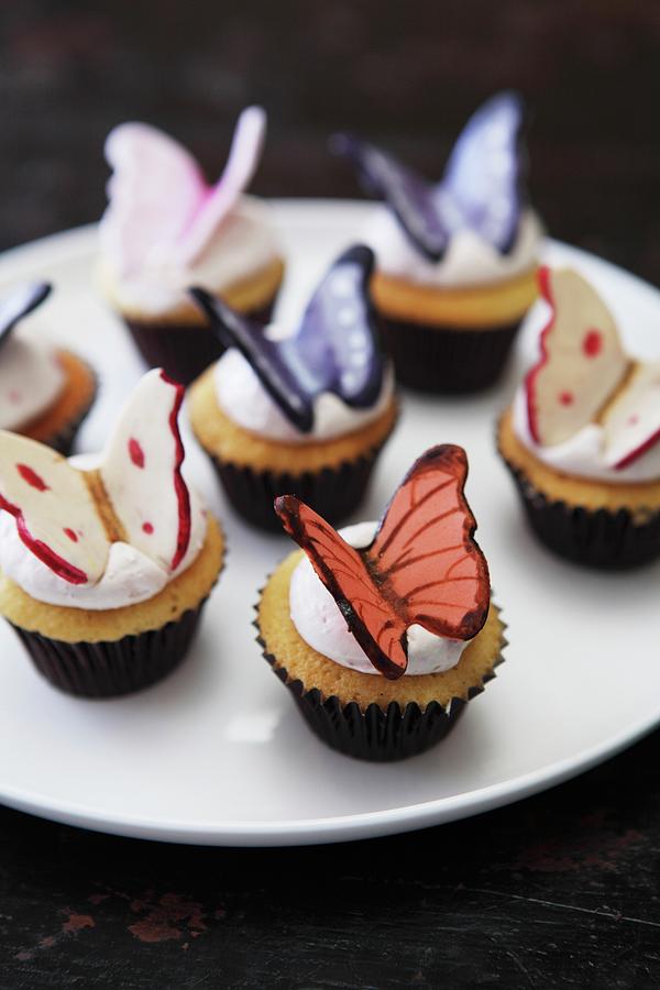 Vanilla Cupcakes With Cream Icing And Chocolate Butterflies Photograph by Trudy Kelder