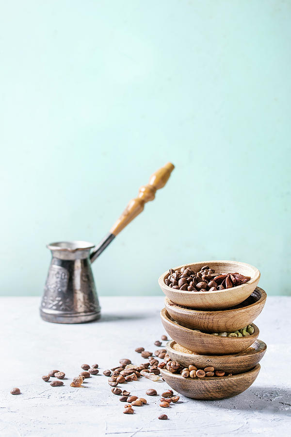 Variety Of Different Coffee Beans And Spices In Wooden Bowls In Stack Over Grey Table Photograph by Natasha Breen