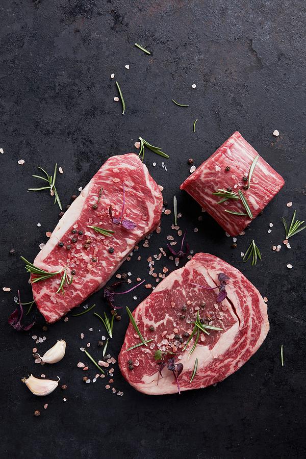 Various Beef Steaks With Herbs And Spices On A Black Background Photograph by Liv Friis
