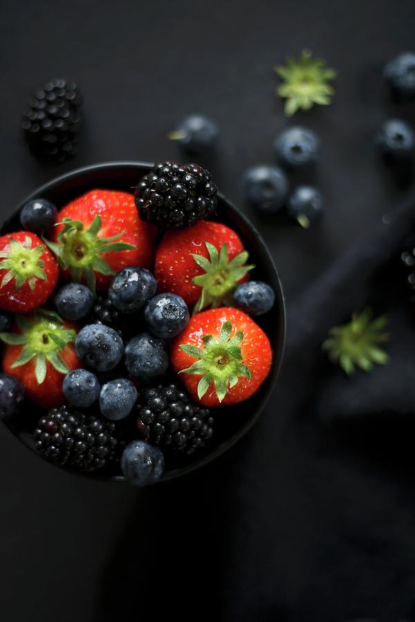 Various Berries In A Black Bowl Photograph by Eva Lambooij