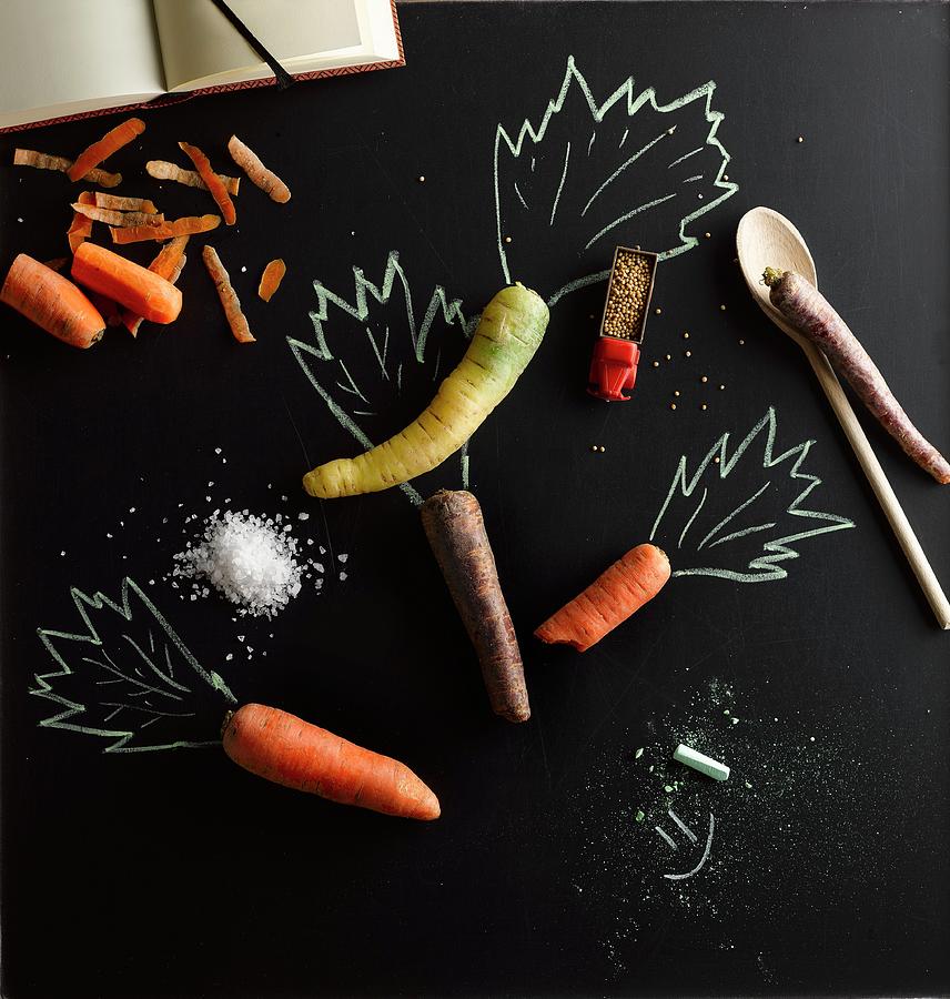 Various Carrots With An Illustration Of Carrot Tops Photograph by Michael Ruder
