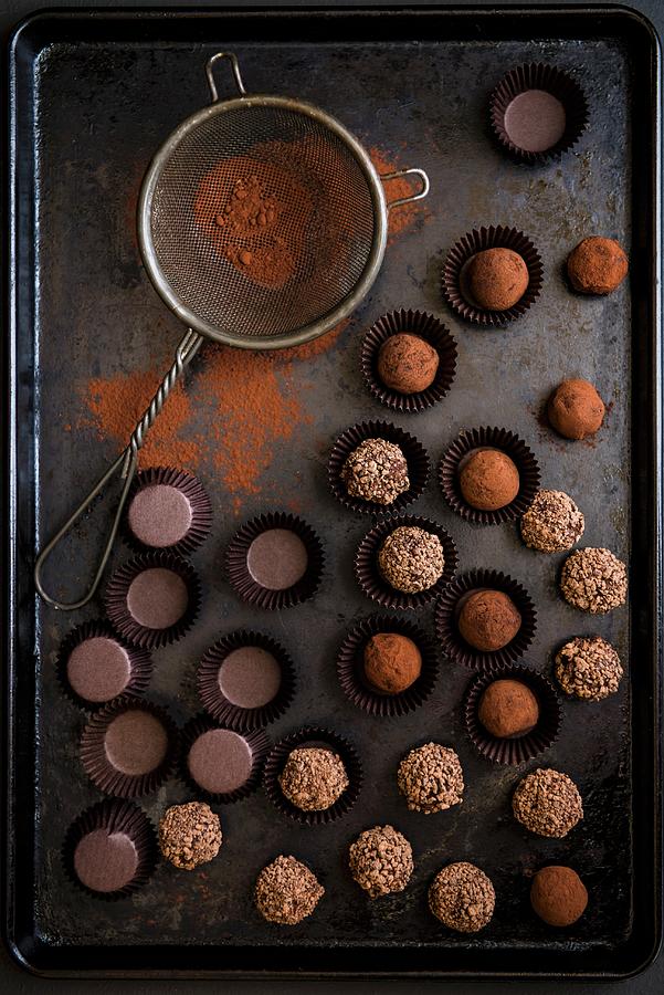 Various Chocolate Truffles With A Sieve And Cocoa Powder On A Baking Tray Photograph by Magdalena Hendey