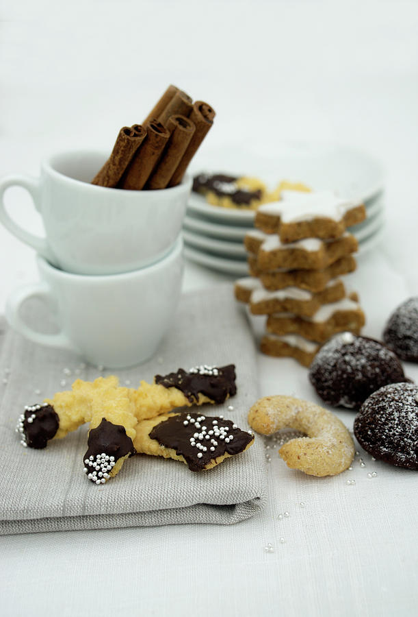 Various Christmas Biscuits And Espresso Cups With Cinnamon Sticks Photograph by Martina Schindler