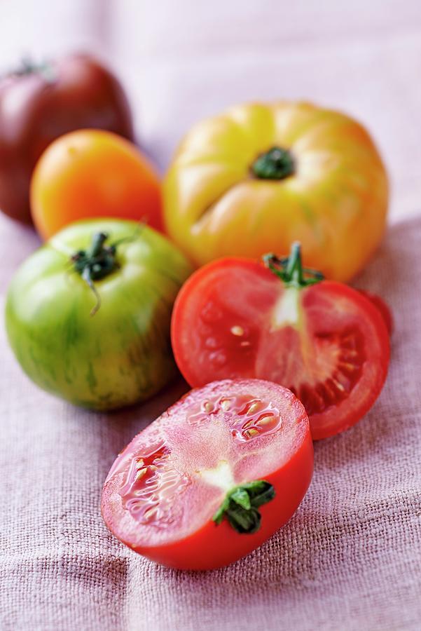 Various Coloured Tomatoes On A Linen Cloth, One Halved Photograph by Bernhard Winkelmann