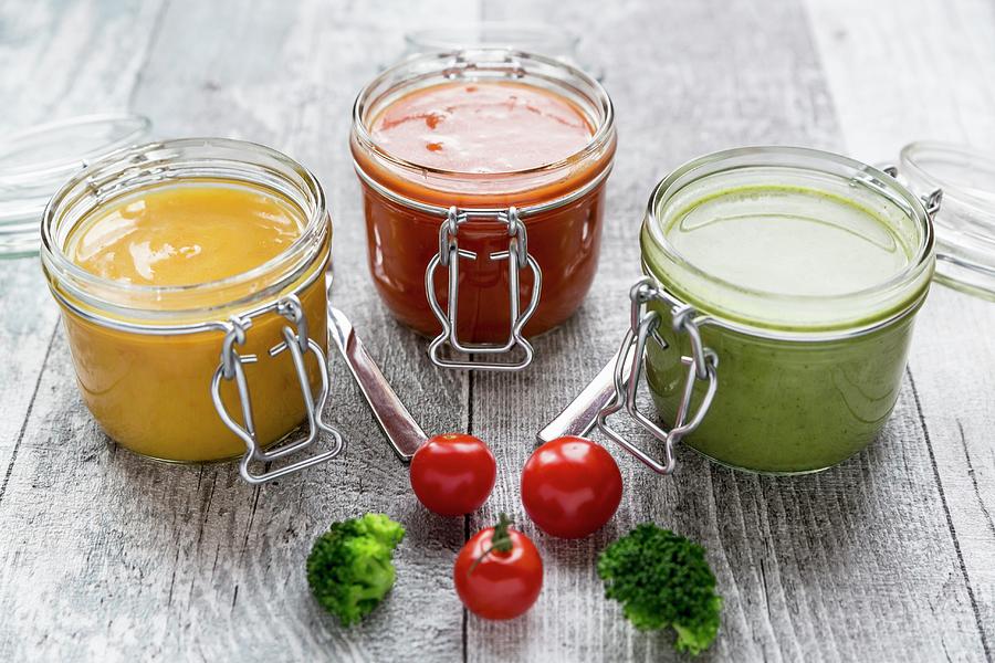 Various Colourful Soups In Glass Jars broccoli Soup, Tomato Soup, Pumpkin Soup Photograph by Sandra Rsch