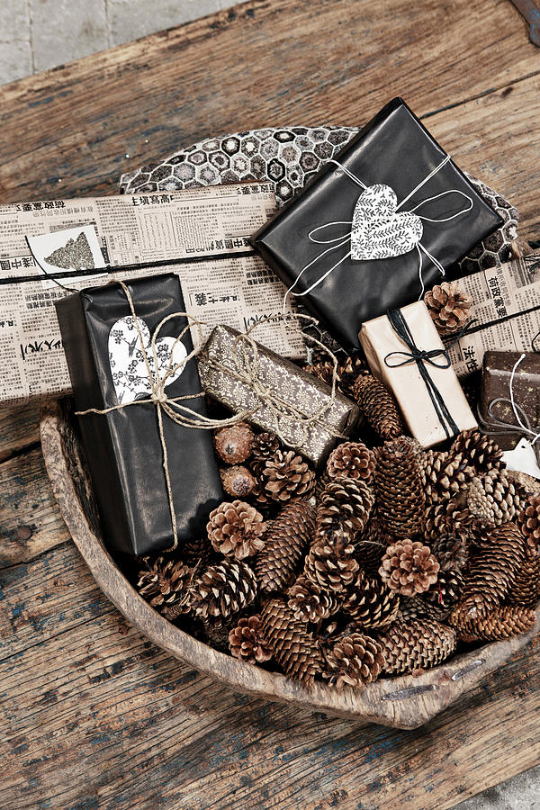Various Conifer Cones And Wrapped Gifts In Wooden Bowl On Rustic Wooden Table Photograph by Lykke Foged & Morten Holtum