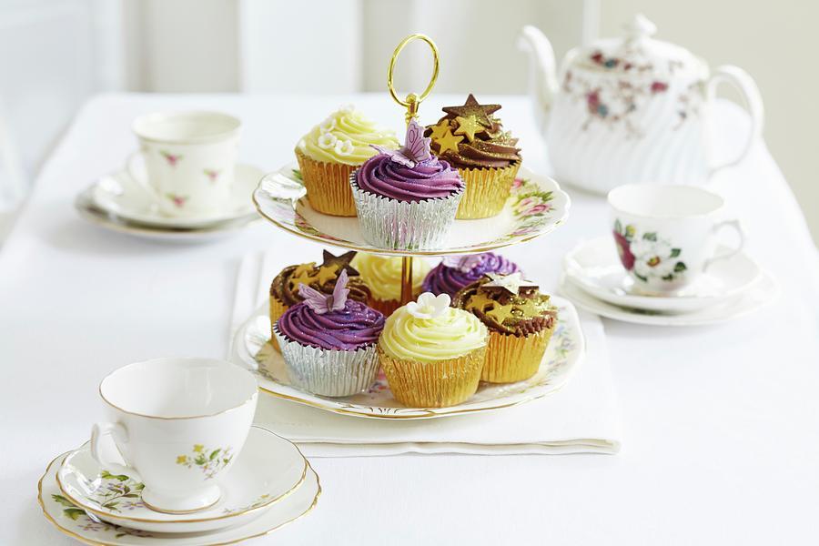 Various Cupcakes On A Cake Stand Between Tea Crockery Photograph by Charlotte Tolhurst