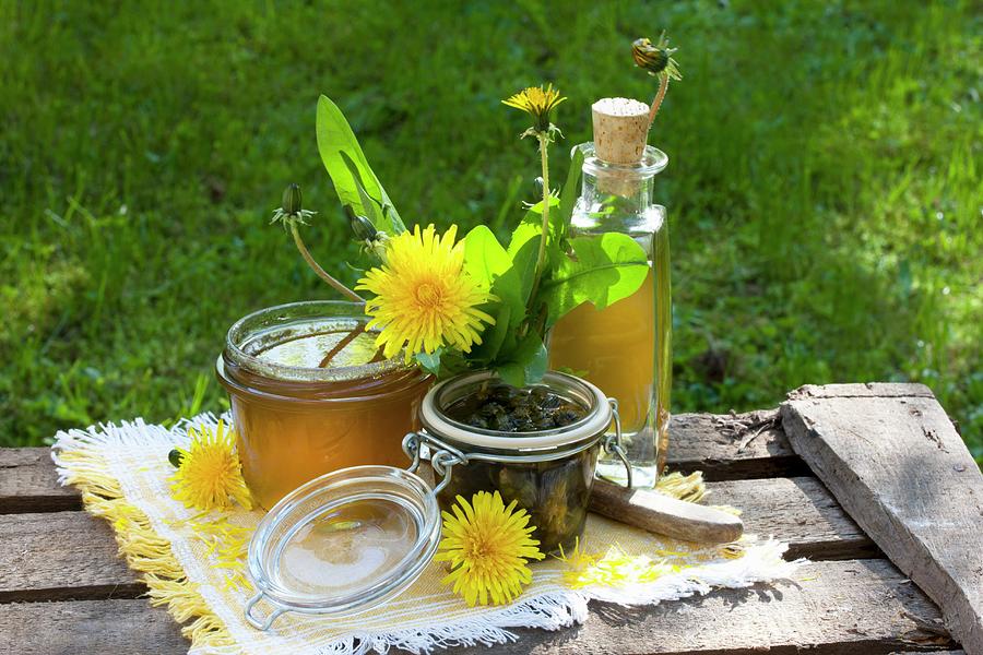 Various Dandelion Products; Jelly, Liqueur And Pickled Buds On Wooden Boards Photograph by Sabine Lscher