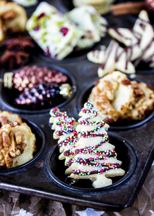 Various Decorated Christmas Biscuits In A Muffin Tray Photograph by Emma Friedrichs