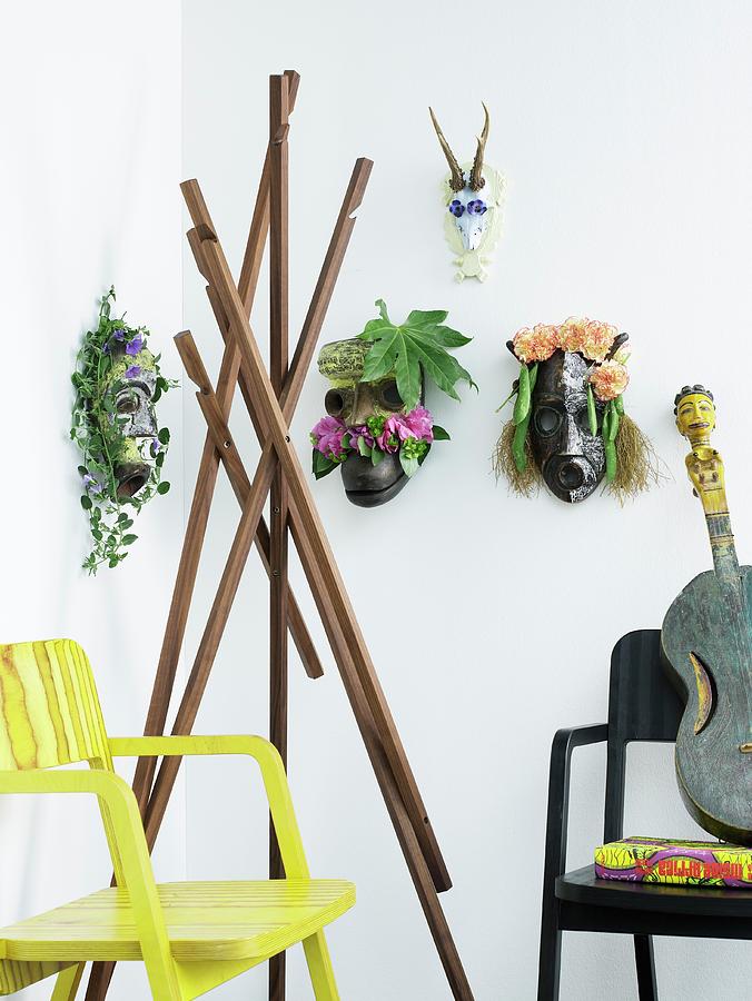 Various Ethnic Animal Masks Decorated With Flowers And Coat Stand Made From Wooden Props Between Armchairs Photograph by Matteo Manduzio