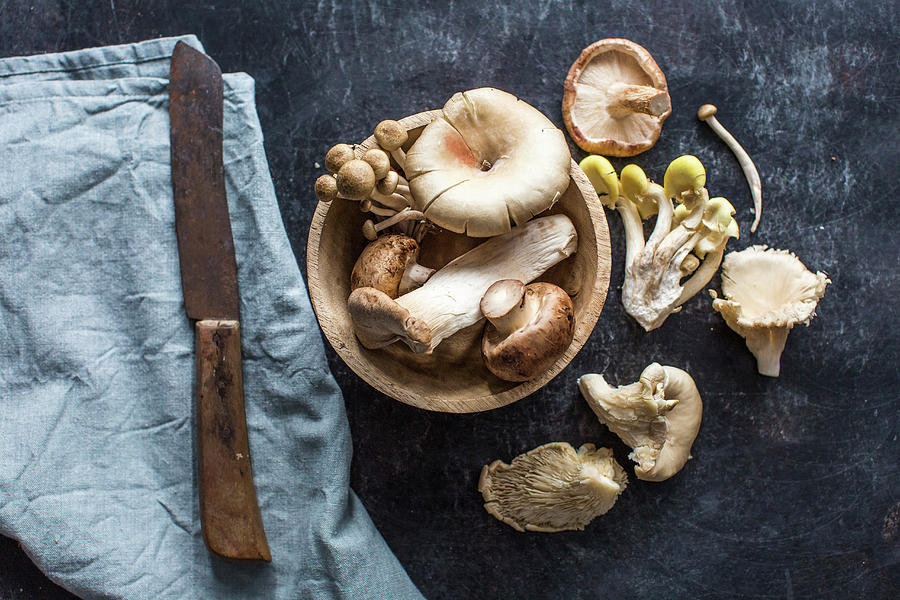 Various Fresh Mushrooms In A Wooden Bowl And Next To It Photograph by Lara Jane Thorpe