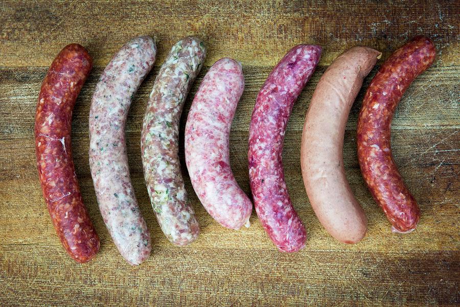 Various Fresh Sausages On A Wooden Surface Photograph by Manuela Rther