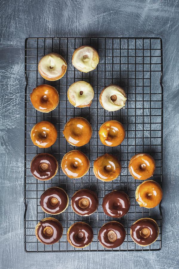 Various Glazed Doughnuts salted Caramel, Dark Chocolate And White Chocolate On A Wire Rack Photograph by Rose Hewartson