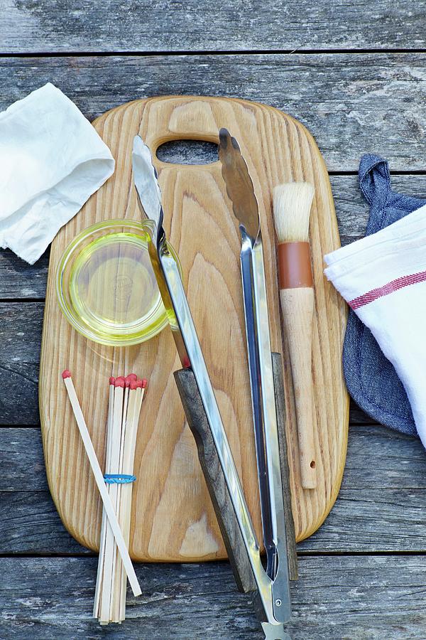 Various Grilling Utensils On A Chopping Board Photograph by Leigh Beisch
