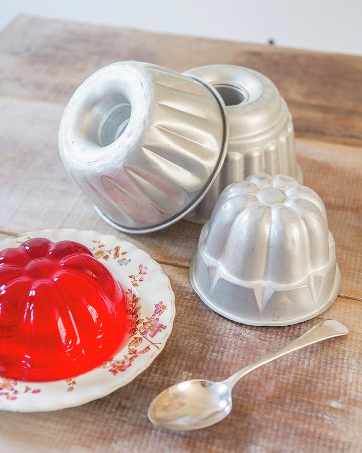 Various Jelly Moulds And Red Jelly On Rustic Wooden Table Photograph by Stuart Cox