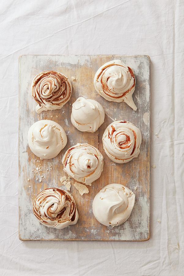 Various Meringues With Chocolate Sauce And Strawberries On A Weathered Wooden Board Photograph by Stacy Grant