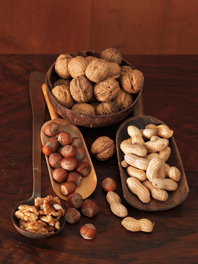 Various Nuts In Wooden Dishes And On A Ladle Photograph by Ulrike Koeb