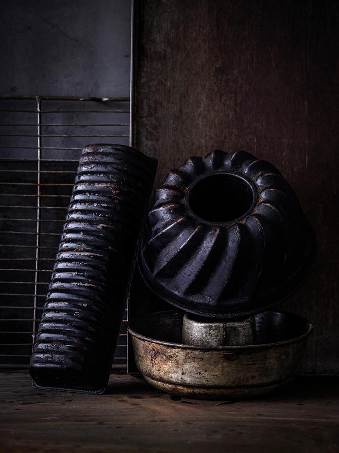 Various Old Baking Tins, Baking Trays And An Oven Rack On A Metal Surface Photograph by Sylvia Meyborg