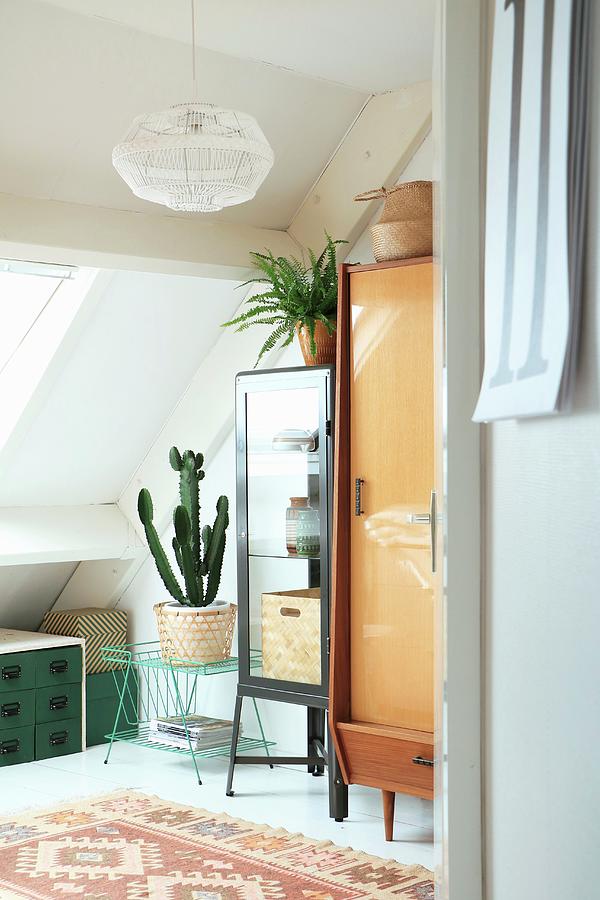 Various Retro Furnishings And House Plants Below Sloping Ceiling Photograph by Marij Hessel