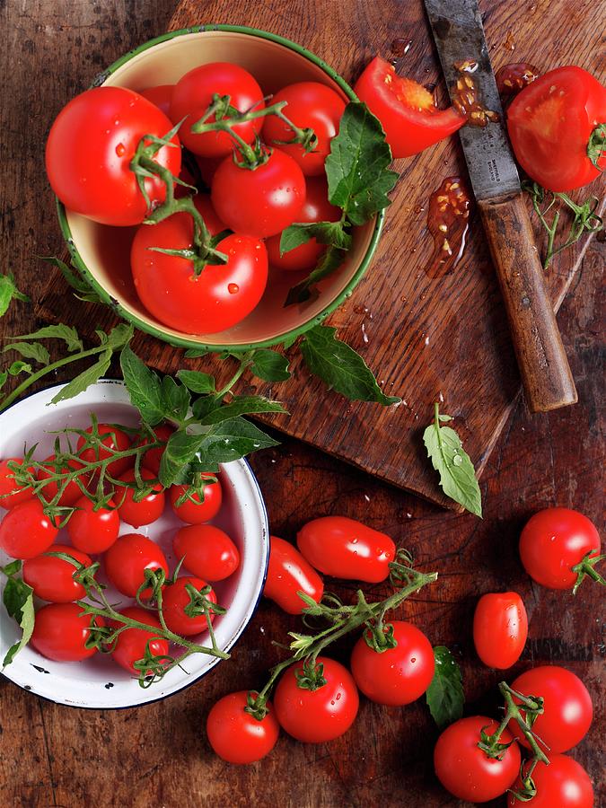 Various Ripe Tomatoes On A Wooden Surface Photograph by Ian Garlick