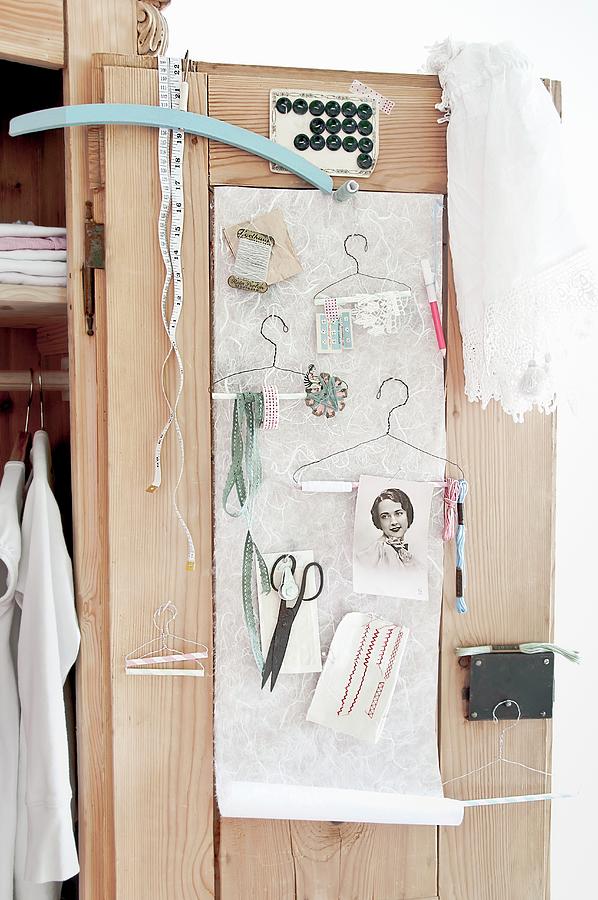 Various Sewing Accessories And Hand-made Wire Coathangers Hung On Cupboard Door Photograph by Cornelia Weber