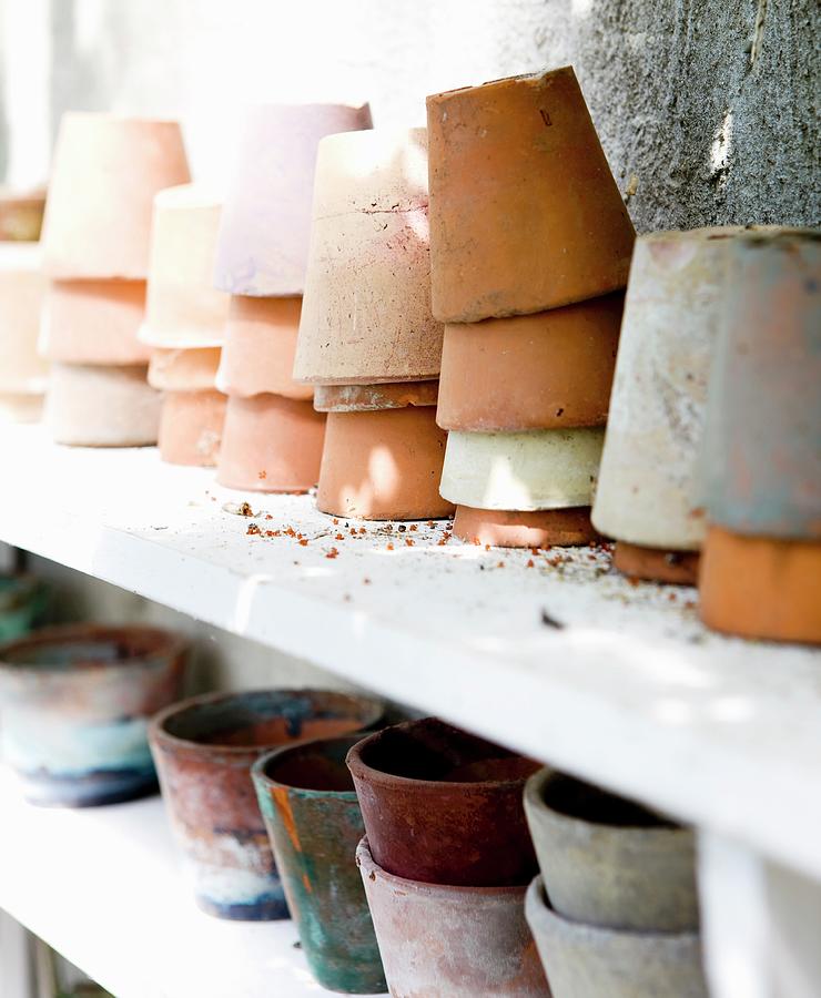 Various Stacked Terracotta Pots On White Shelf Photograph by Lene-k