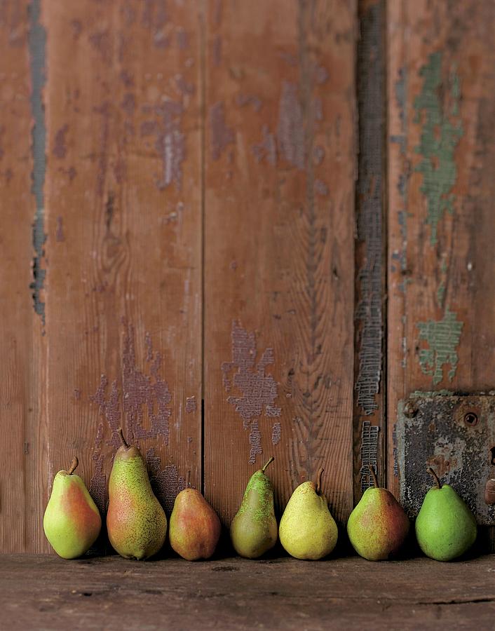 Various Types Of Pears In A Row Against A Wooden Wall Photograph by Jalag / Wolfgang Schardt