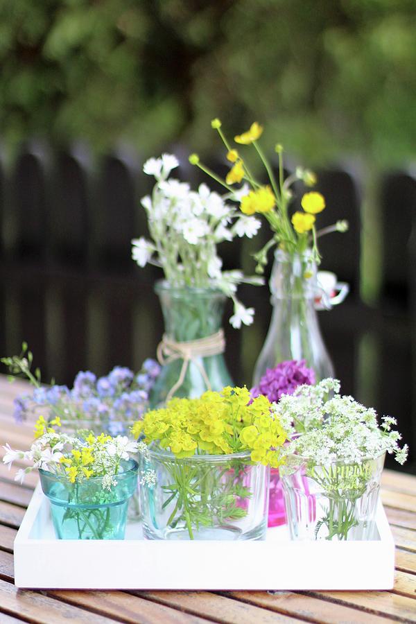 Various Wild Flowers In Glass Vessels On Garden Table Photograph by Sylvia E.k Photography
