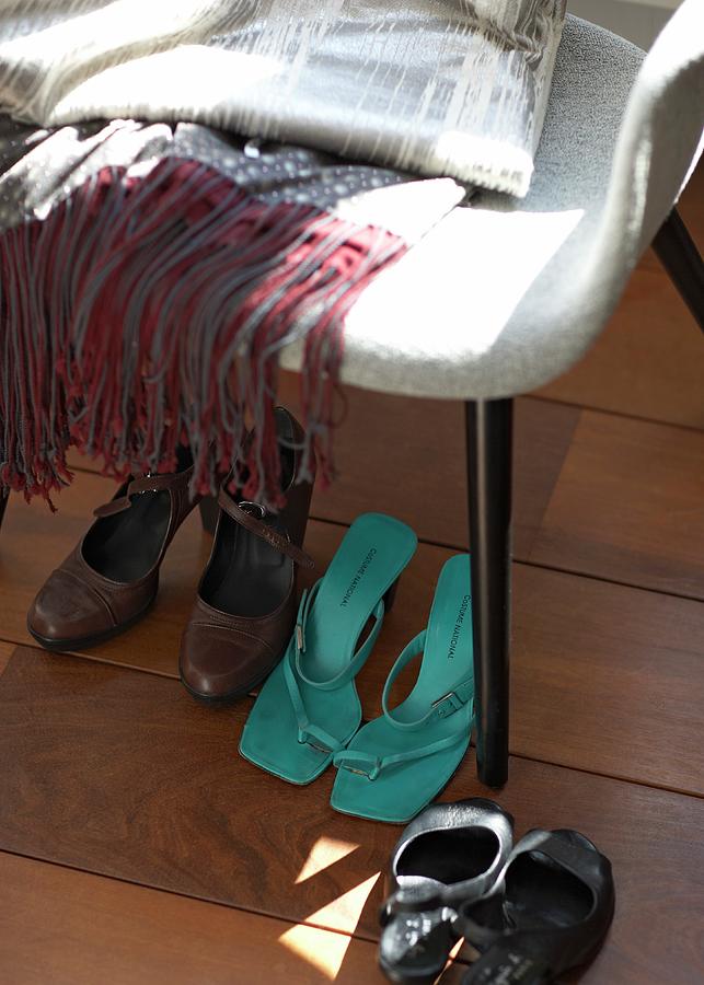 Various Womens Shoes Under Chair On Dark Floorboards Photograph by Alexander Van Berge