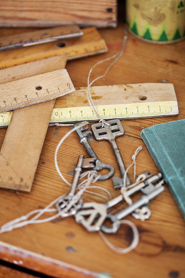 Various Wooden Rulers And Vintage Keys On Table Photograph by Lina stling