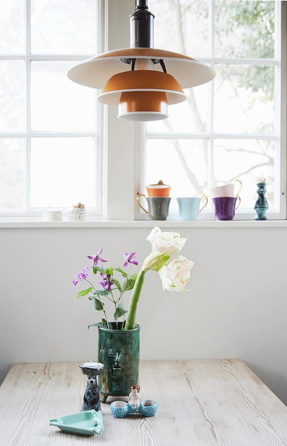 Vase Of Flowers On Table Below Designer Lamp In Front Of Window Photograph by Nicoline Olsen