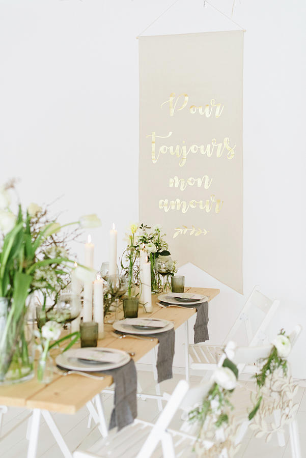 Vase Of Tulips, Dry Twigs And Pillar Candles On Table With Message On Wall In Background Photograph by Katja Heil