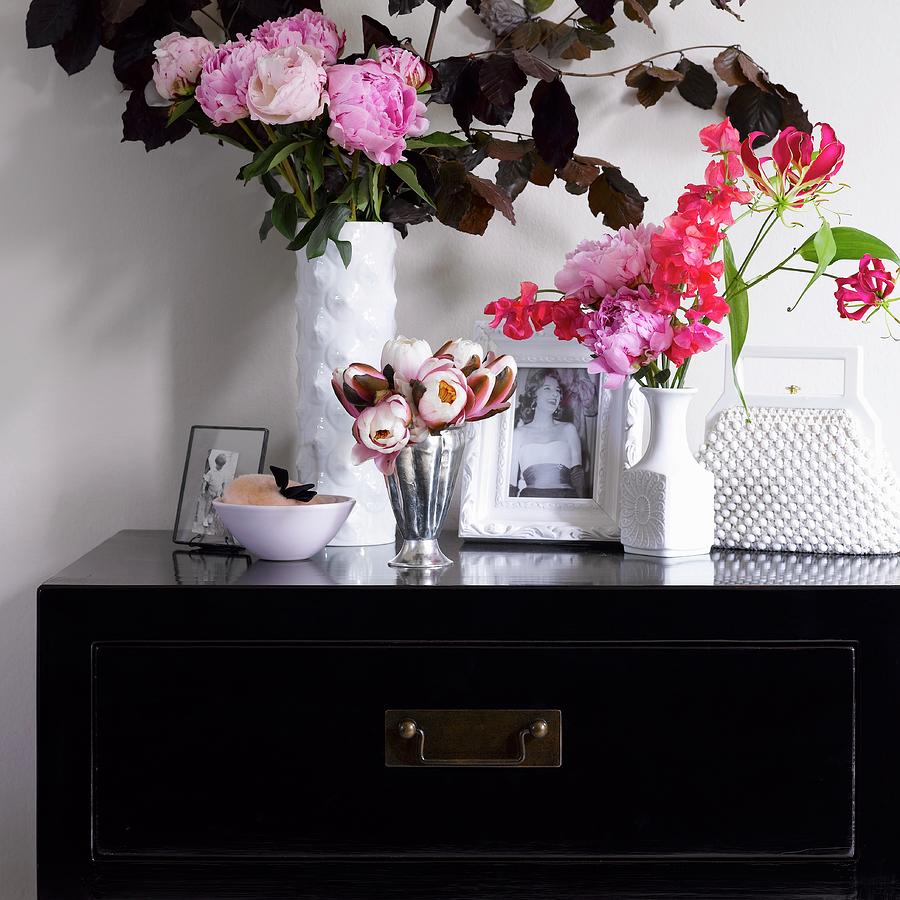 Vases Of Flowers, Photos And Handbag On Black Chest Of Drawers Photograph by Dan Duchars