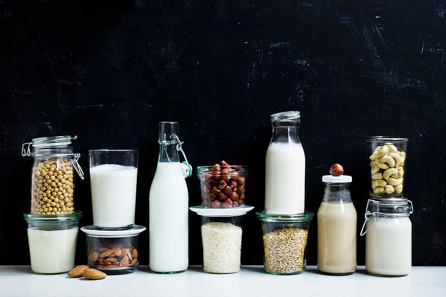 Vegan Milk And Ingredients On A Black Surface Photograph by Brigitte Sporrer