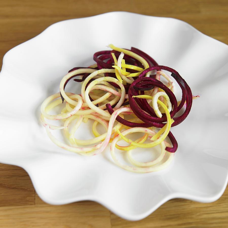 Vegetable Spaghetti Made From Beetroot And Yellow Courgettes On A White Plate Photograph by Allison Dinner