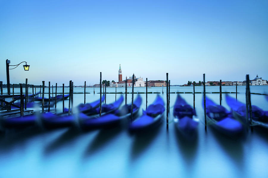 Venice, gondolas or gondole on sunset and church on background. Italy Photograph by Stefano Orazzini