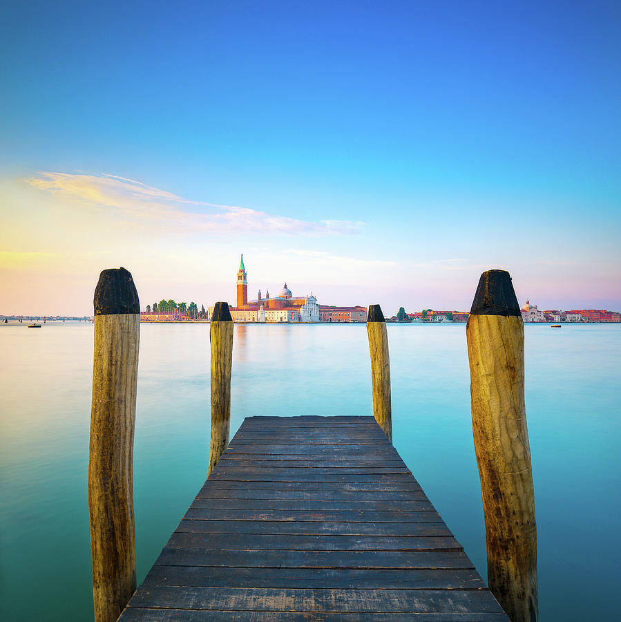 Venice lagoon, wooden pier or jetty and  poles and church on bac Photograph by Stefano Orazzini