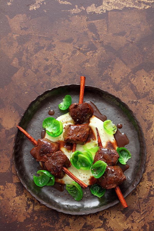 Venison Skewers With Cinnamon On A Bed Of Celery Cream Photograph by Jalag / Mathias Neubauer