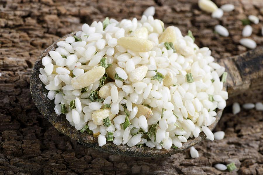 Vialone Nano Risotto Rice With Pine Nuts And Chives On A Wooden Spoon Photograph by Diez, Otmar