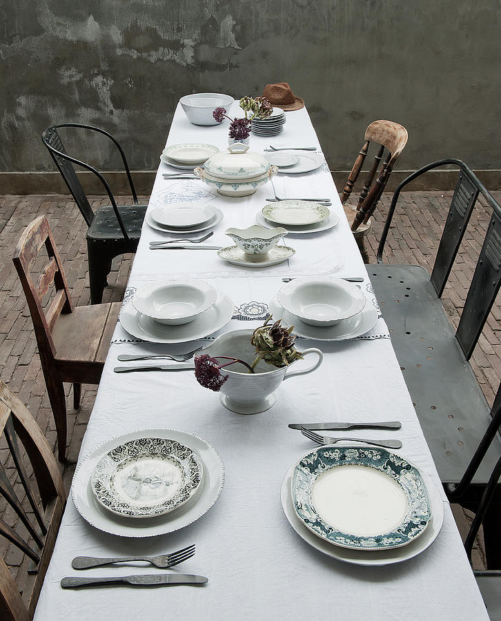 View Along Table Set With White Tablecloth And Various Chairs ...