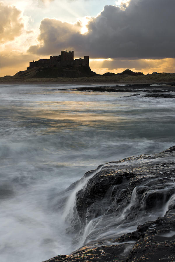 View Of Bamburgh Castle At Sunset Photograph by David Clapp