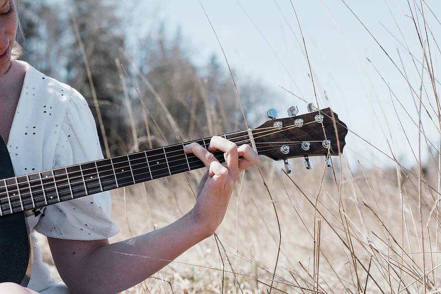 Music Photograph - View Of Womans Hand Playing Guitar In A Field In Summer by Cavan Images