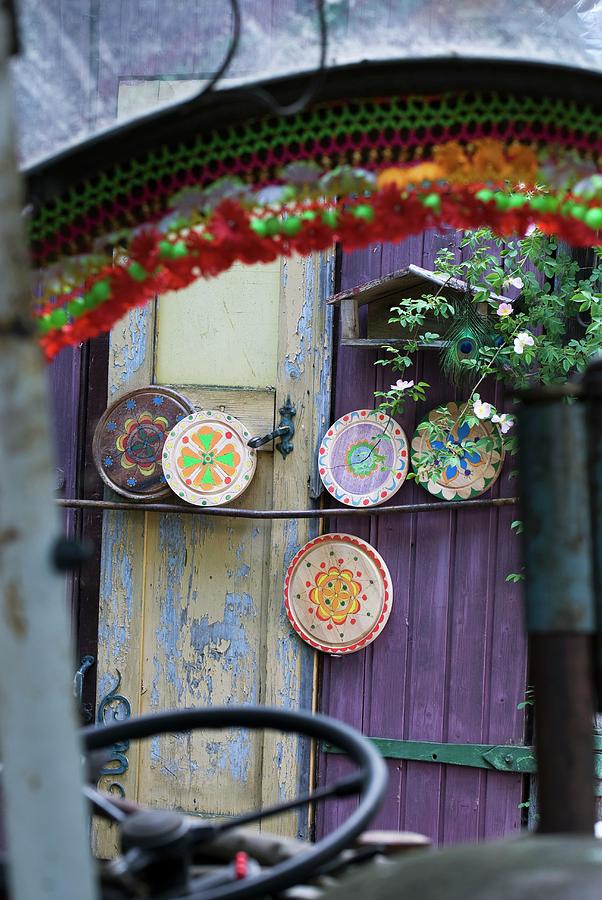 View Through Vehicle Windscreen Of Round Chopping Boards Painted With Colourful Patterns Leaning On Purple Painted Wooden Door Photograph by Matteo Manduzio