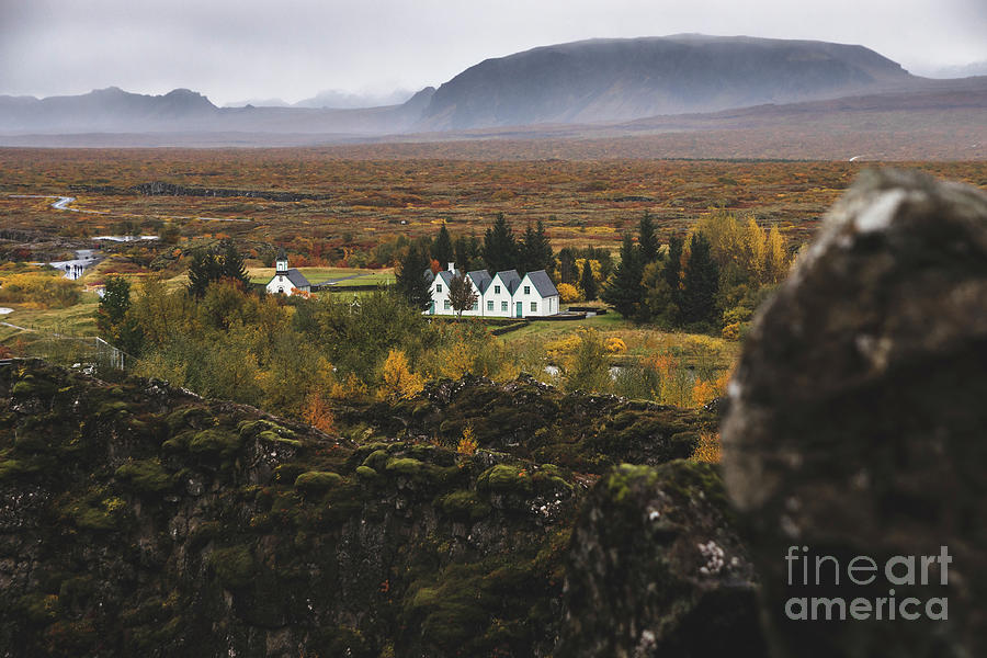 Village with farms in a rural area of the mountains of Iceland, with snowy mountains in the background. Photograph by Joaquin Corbalan