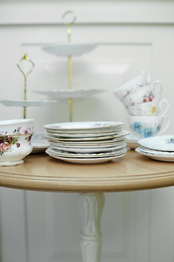 Vintage Crockery plates, Cups And A Cake Stand On A Table Photograph by Magdalena Hendey