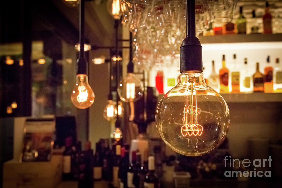Abstract Photograph - Vintage lamp bulb with bar or cafe night abstract background  by Luboslav Tiles