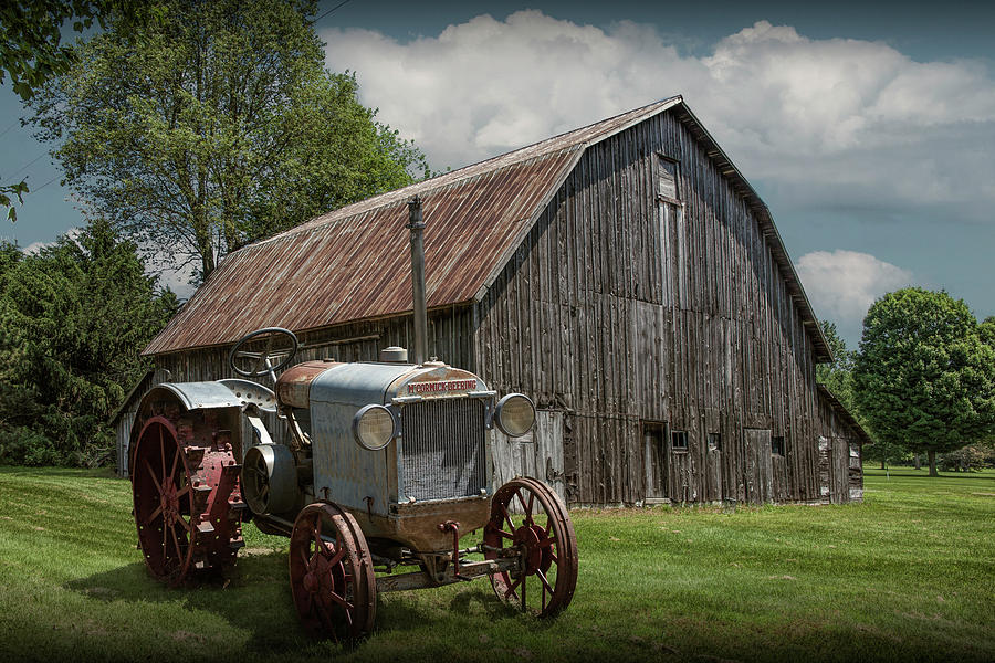 Vintage McCormick-Deering Tractor with old weathed Barn in a Rus Photograph by Randall Nyhof