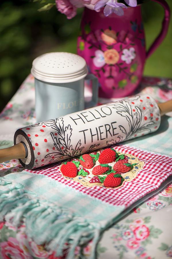 Vintage-style Arrangement Of Rolling Pin With Written Motto And Crocheted Strawberries On Tablecloth On Garden Table Photograph by Winfried Heinze