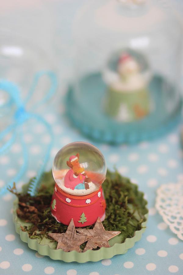 Vintage-style Arrangement Of Snow Globe On Moss In Pale Green Flan Tin Photograph by Ruth Laing